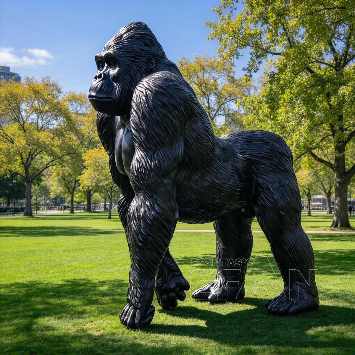 Glossy black bronze gorilla statue displayed on a park lawn