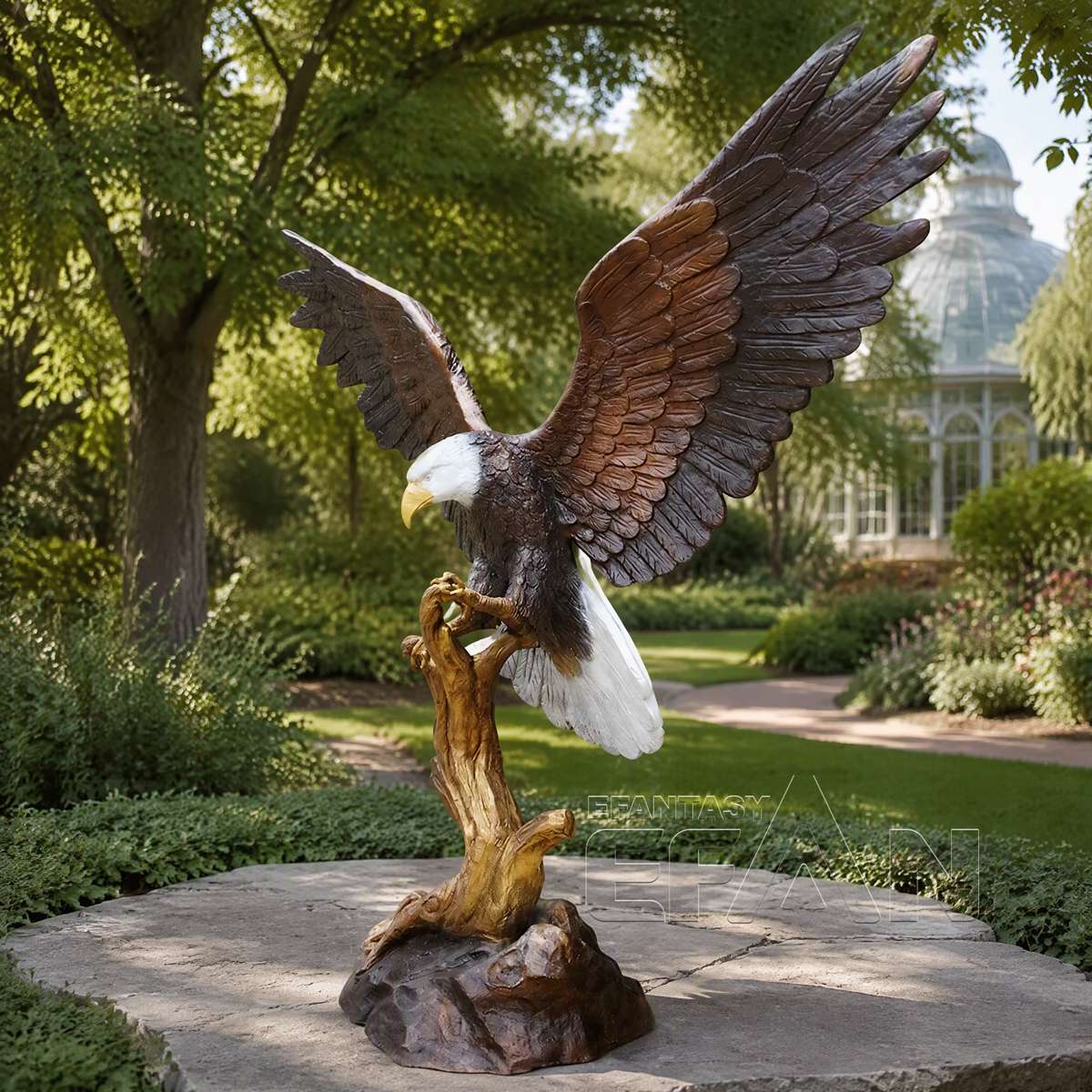 Side view of bronze bald eagle statue perched on a tree branch in a garden