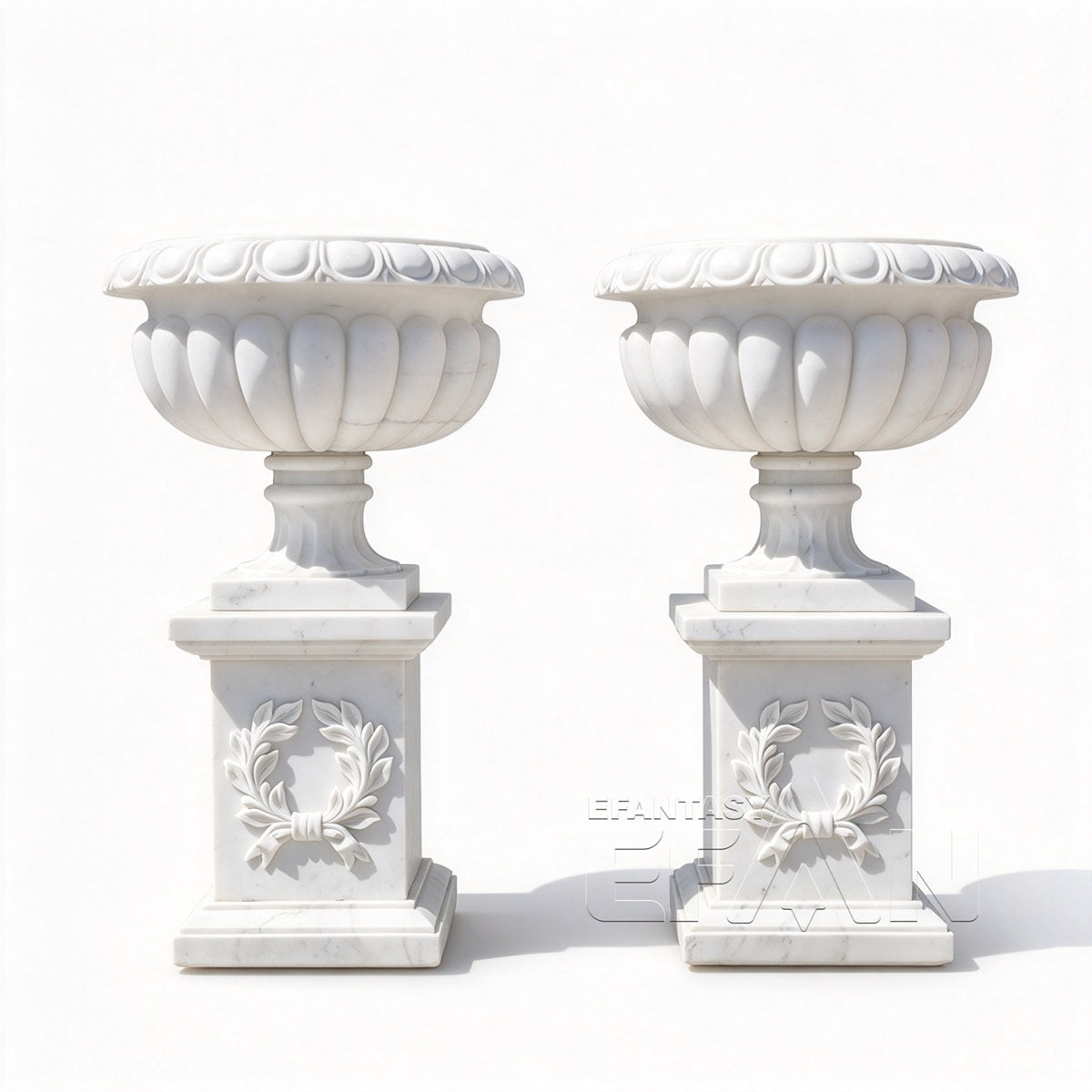 Two white marble fluted urn planters with carved laurel wreath pedestals on a white background