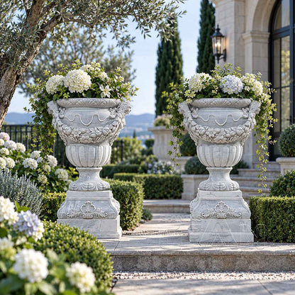 Two white marble relief planters holding white flowers beside an estate terrace