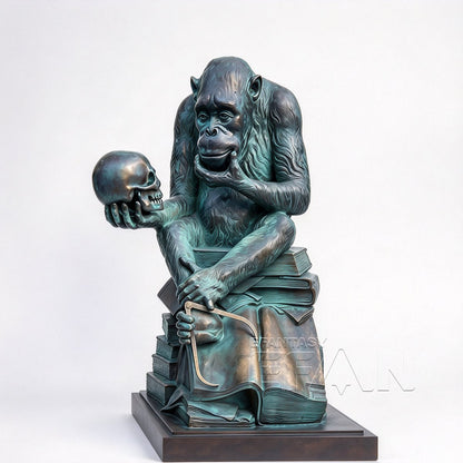 Green patina bronze gorilla holding a skull while seated on sculpted books, white background